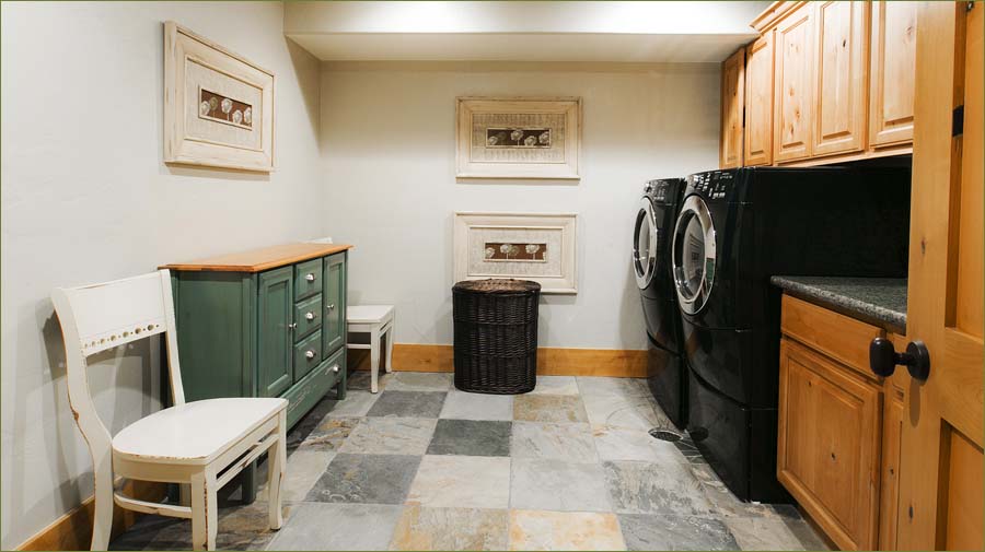Large laundry room with full sized front loading washer and dryer.