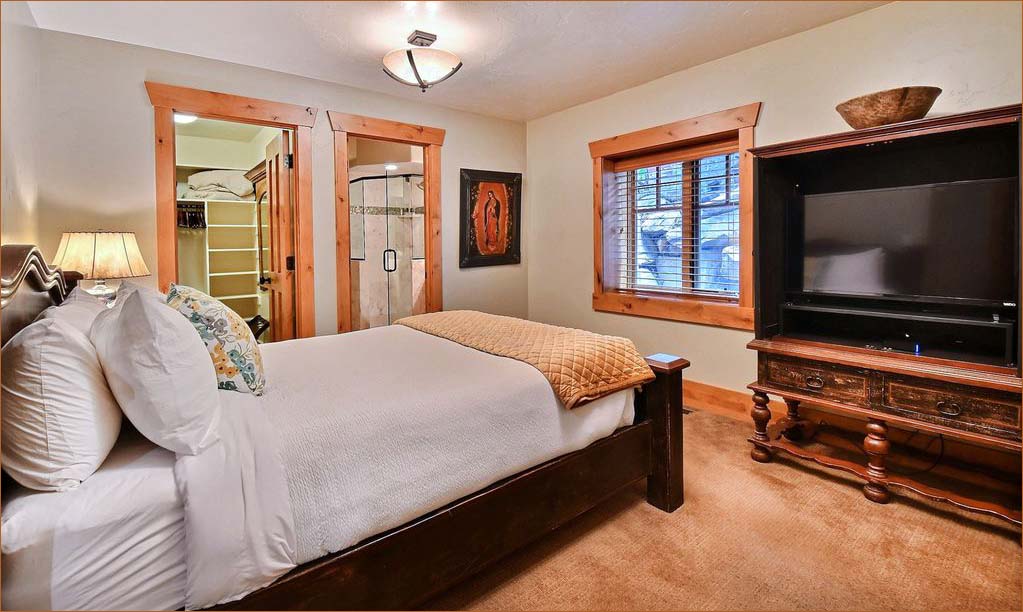Old Town Park City home includes a second master bedroom with a plump queen bed, private TV/DVD and private bathroom with large glass shower and vanity.