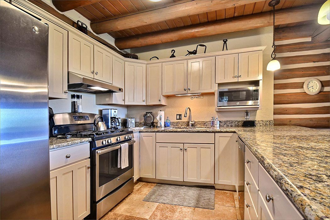 Fully equipped kitchen features granite countertops and a family dining room table.